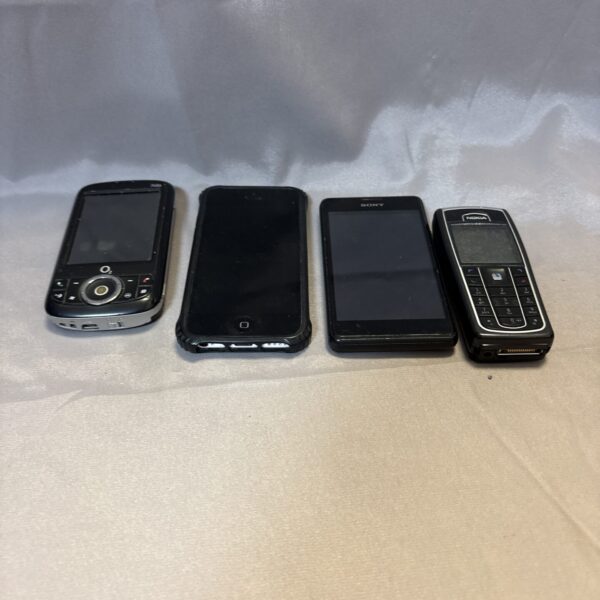 Silver iPhone in a bundle of vintage mobile phones.