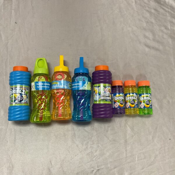 Colourful multi-sized bubble solution bottles for kids' outdoor play.