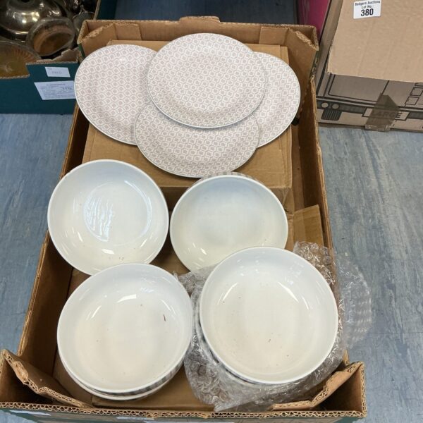 White Next crockery set stacked on a cardboard box.