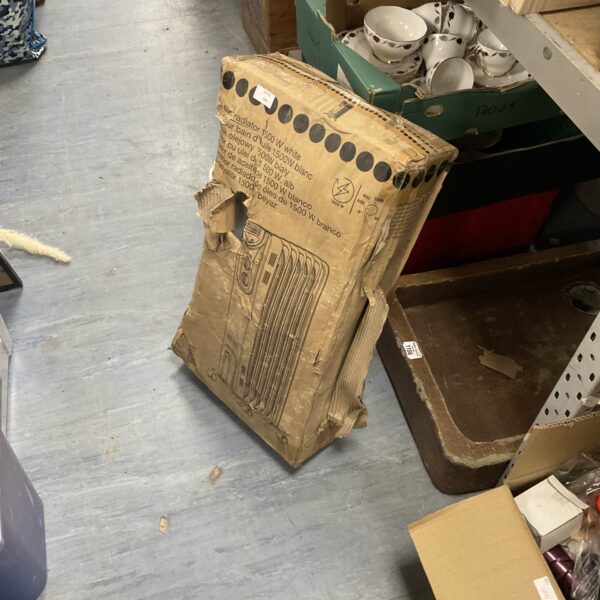 Unused oil filled radiator in original packaging for home heating.