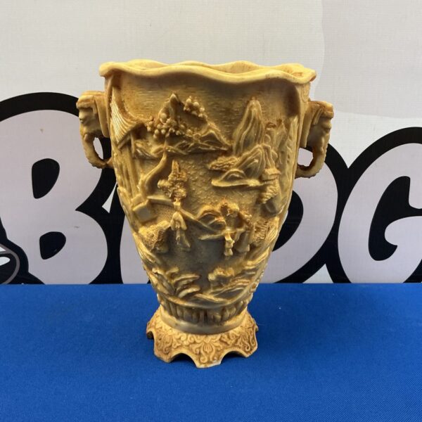 Detailed Oriental resin vase with elephant head handles.
