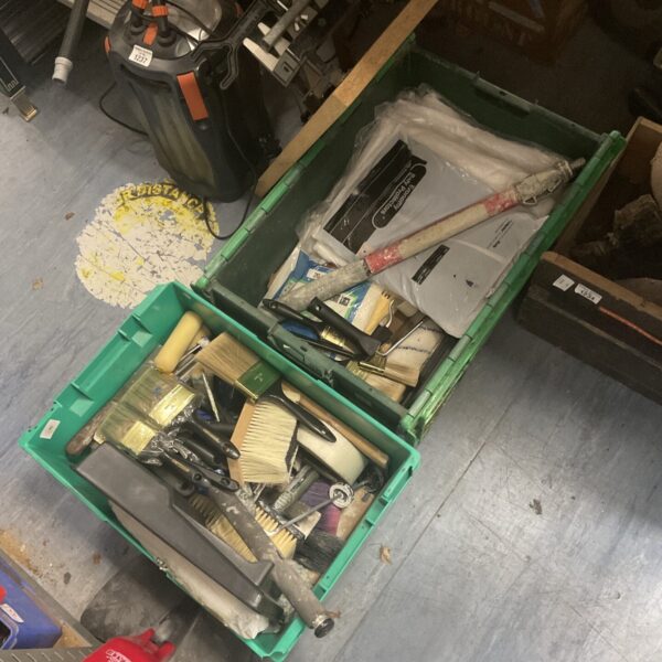 Two green crates filled with painter's and decorator's tools.