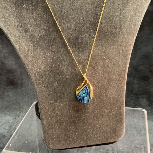 Iridescent paua shell necklace with 14 carat gold pendant.