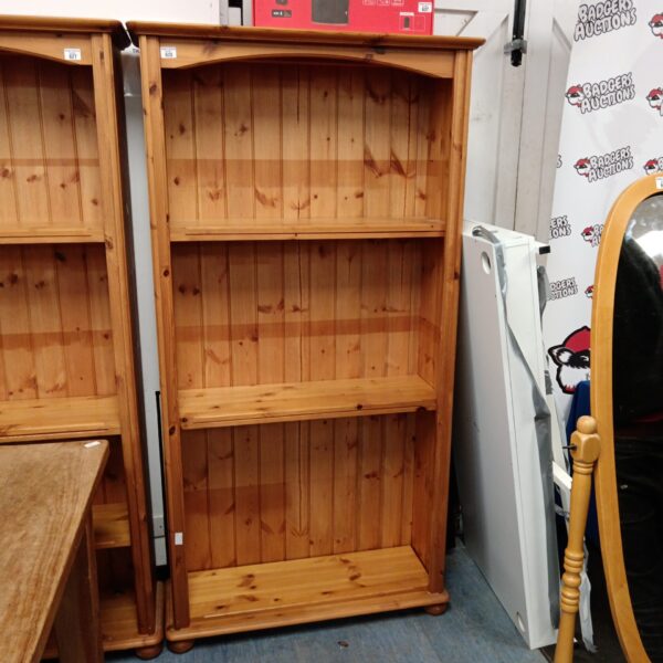 Tall pine bookcase with multiple shelves for home storage.