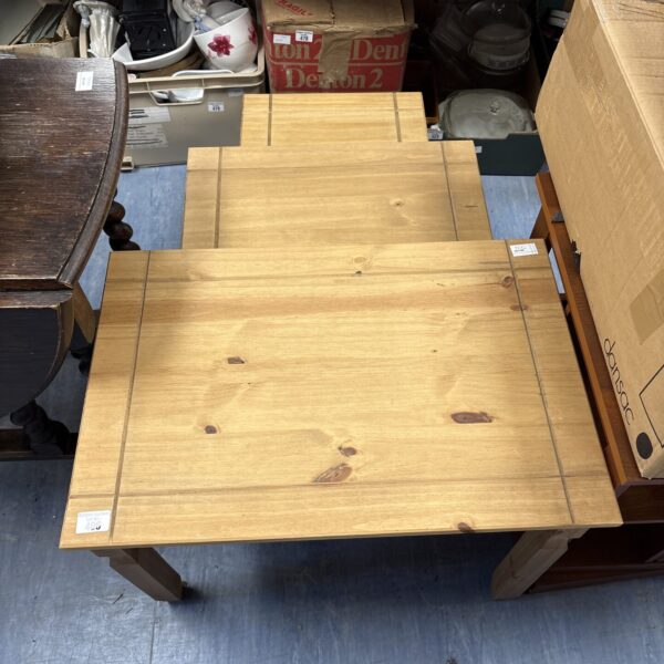 Set of three vintage pine nest of tables with varying sizes.
