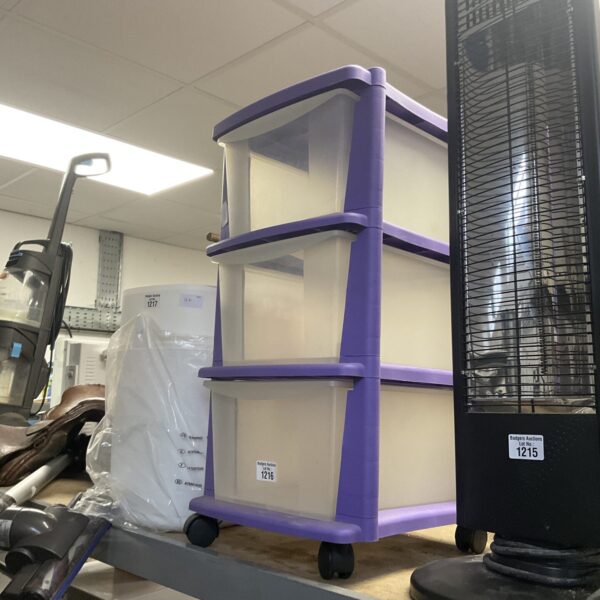 Purple plastic three-drawer cabinet on wheels for storage.