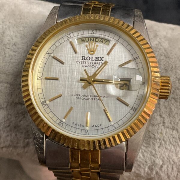 Gold tone quartz wristwatch with day-date complication.