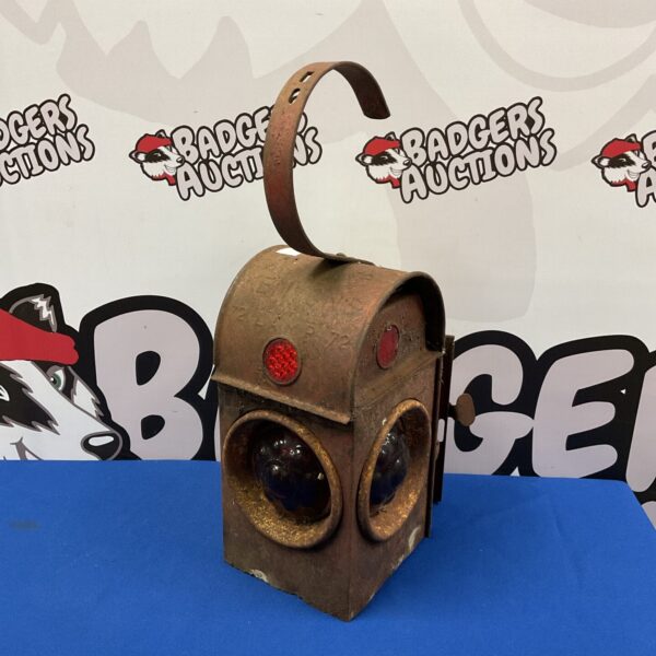 Vintage railway lantern with red glass, front view.