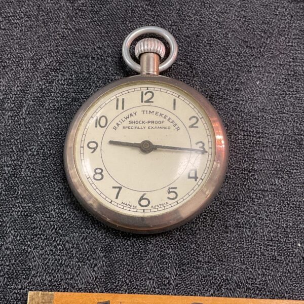 Antique railway pocket watch with white enamel dial.
