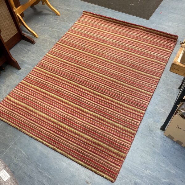 Vintage striped rug with red, green, and beige colours.