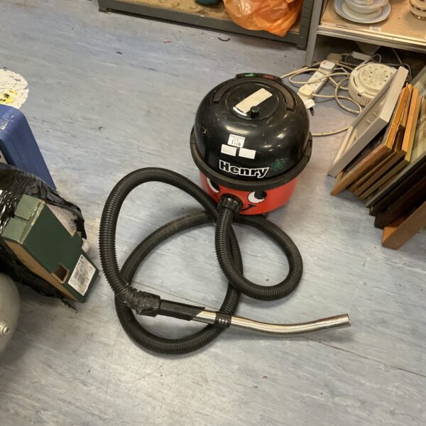 Red Numatic Henry Hoover with hose visible.