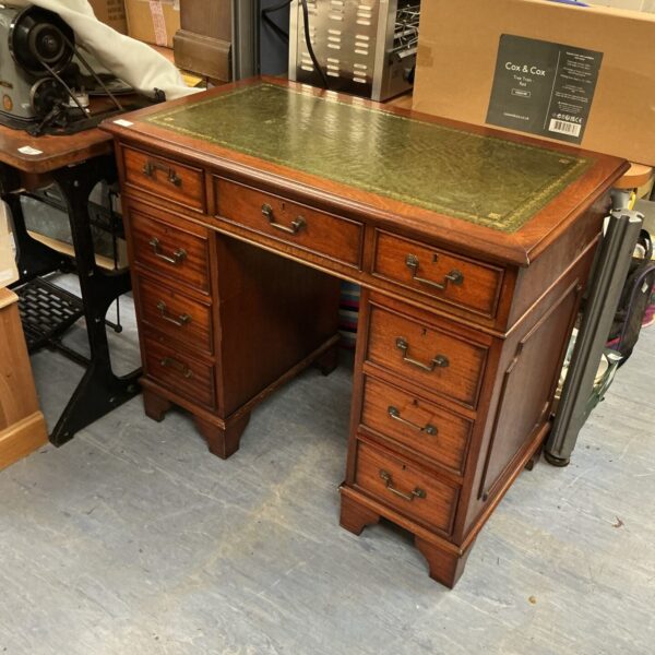 Small reproduction leather top desk with green writing surface.