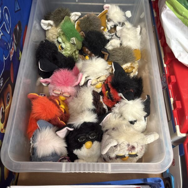 A collection of vintage Furbys in a storage container.