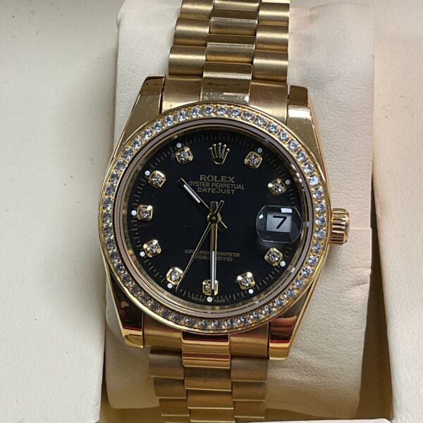 Gold Rolex Datejust style watch with black dial and fluted bezel.