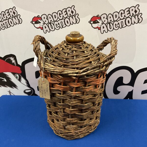 Vintage Royal Navy rum flagon with wicker binding, a collectible nautical item.
