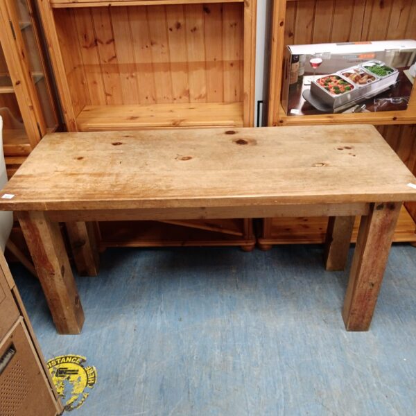 Rustic pine kitchen table with a chunky design and visible wood grain.