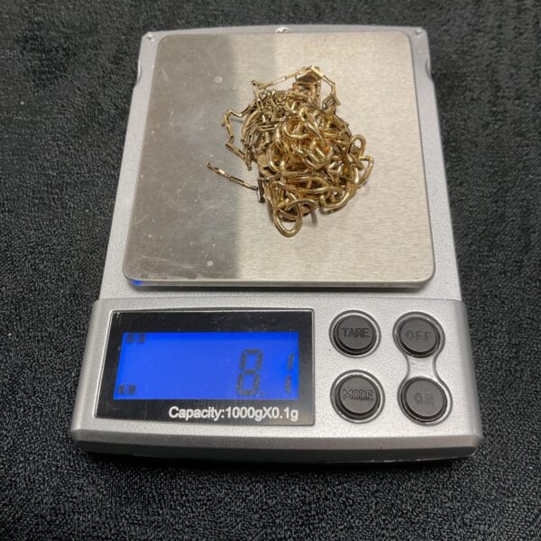 Close-up of 8g scrap 9ct gold lot for refining.