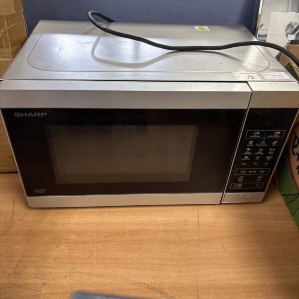 Vintage Sharp microwave appliance in a kitchen setting.