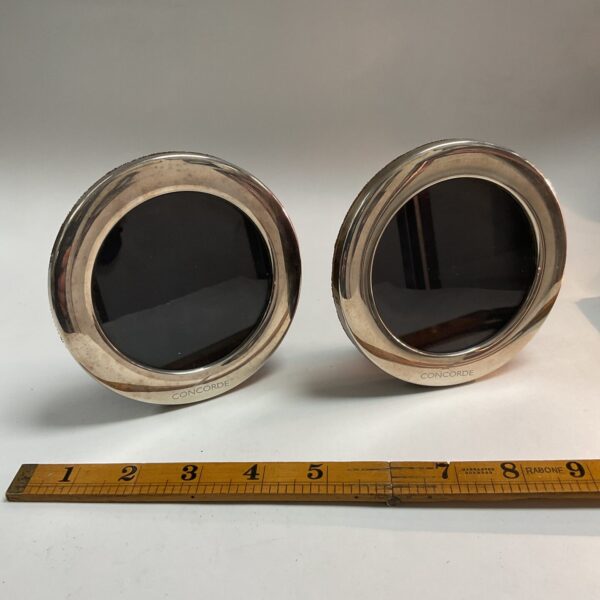 Pair of vintage silver Concorde picture frames on ruler.
