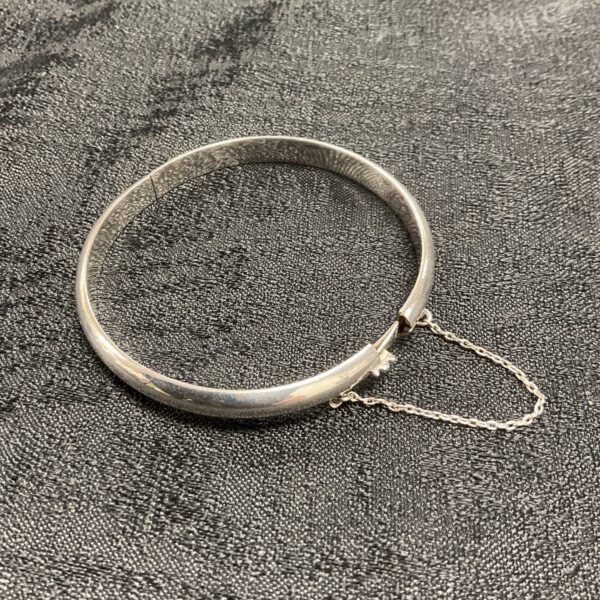 Vintage silver hinged bracelet with safety chain.