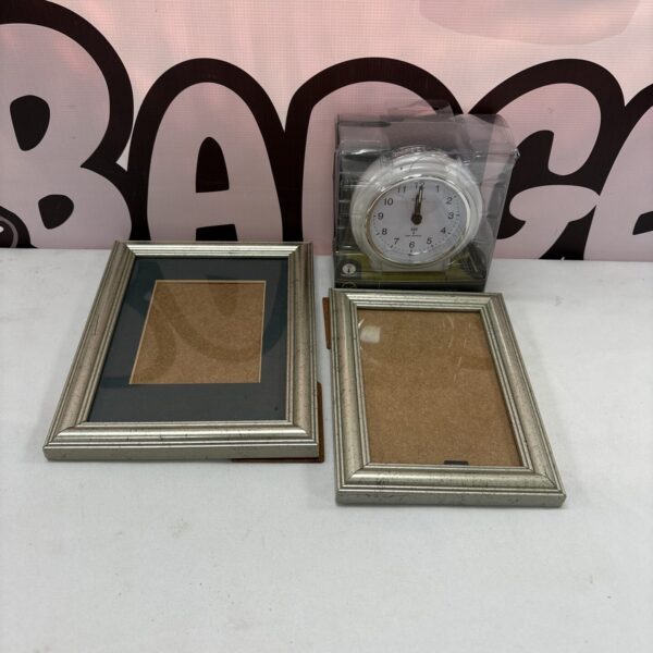 Silver photo frames and Acctim alarm clock set on display.