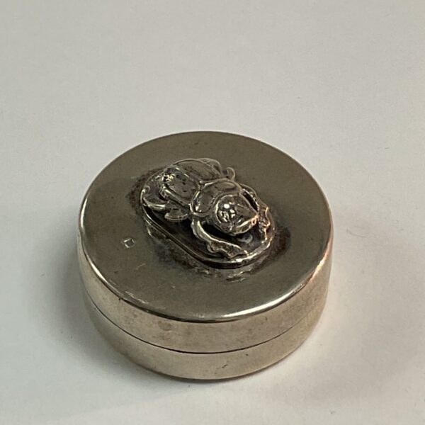 Antique silver pill pot with detailed beetle lid.