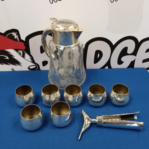 Antique silver plate pitcher and Wm a Rogers cups set on display.