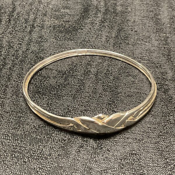Close-up of intricate silver puzzle bracelet design.