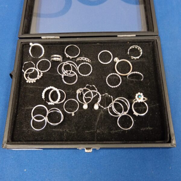 Silver tone ring lot displayed in a box.