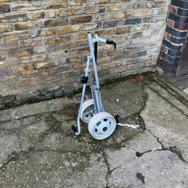 Vintage Slazenger golf trolley with three wheels.