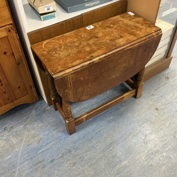 Antique oak gate leg table with drop leaf design.