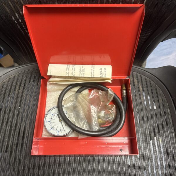 Vintage Snap On oil pressure gauge set with black face and hoses.