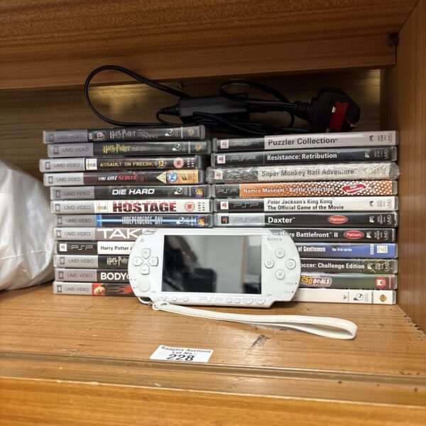 White Sony PSP console with game discs, a classic handheld gaming system.