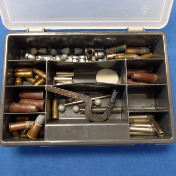 Collection of spent bullet casings in a plastic box.