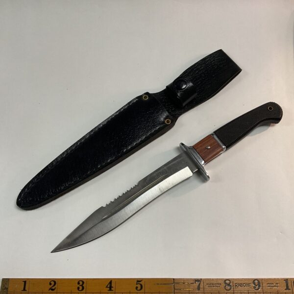 Stainless steel sheath knife with black sheath, showing blade and handle.