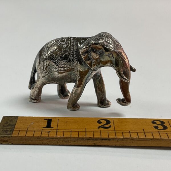 Intricate sterling silver elephant figurine with detailed etching.