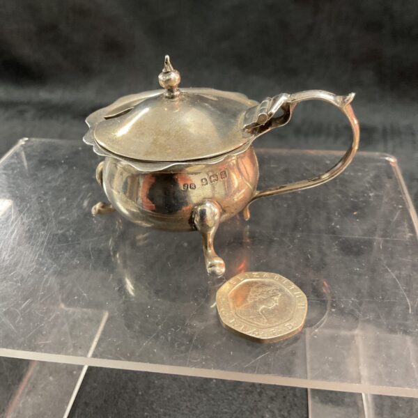 Hallmarked sterling silver mustard pot with hinged lid and scroll handle.