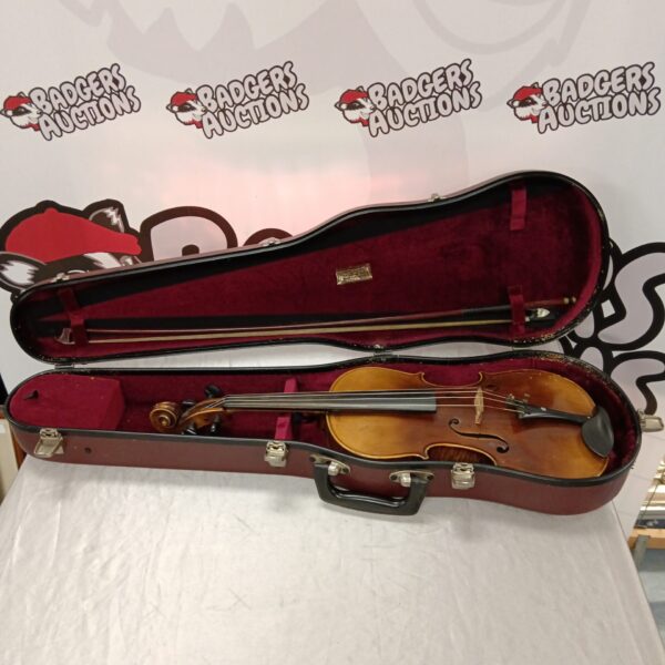 Vintage Stradivarius replica violin with bow and case, a classic stringed instrument.