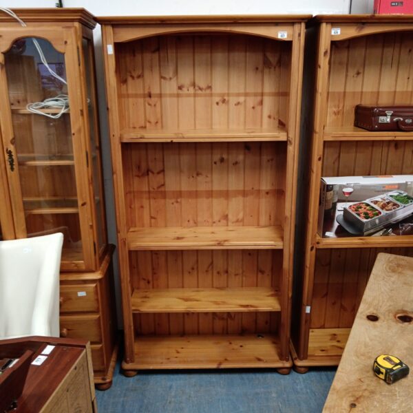 Tall pine bookcase with multiple shelves for home storage and display.