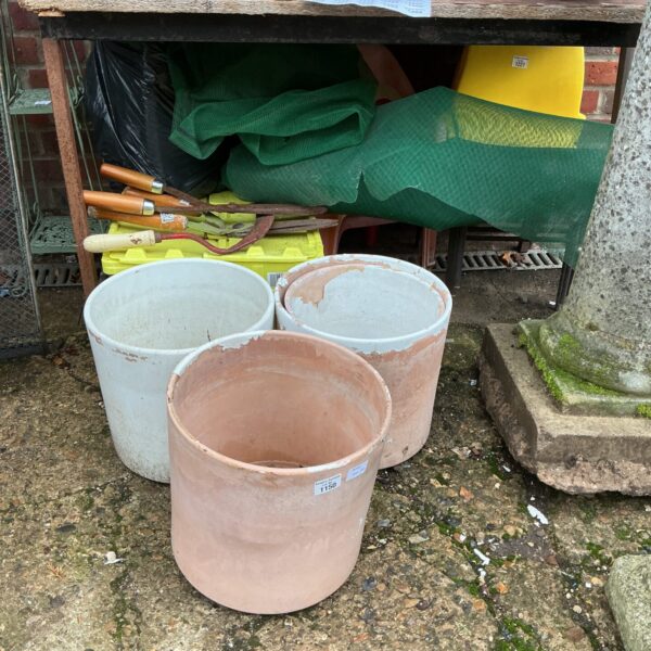 Rustic terracotta planters in a garden setting, ideal for plants.