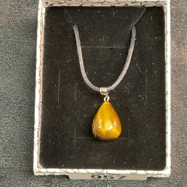 Close-up of a striking tigers eye pendant on a black rope necklace.