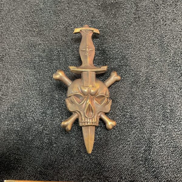 Front view of reproduction Totenkopf badge with skull and crossbones.