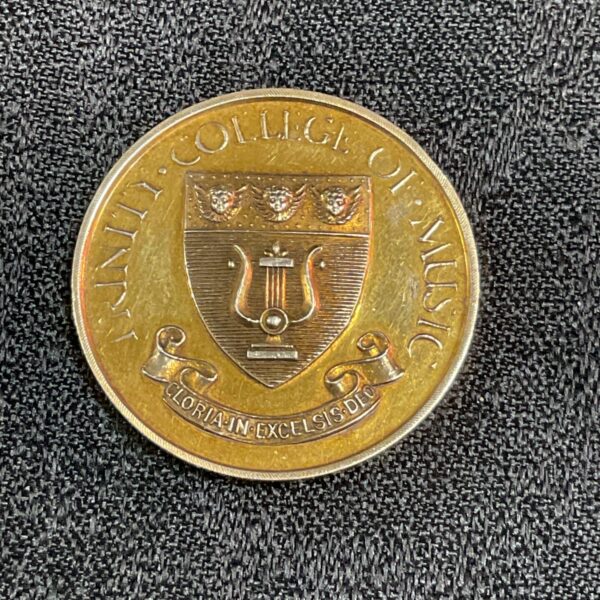 Front view of antique Trinity College of Music brass medal.
