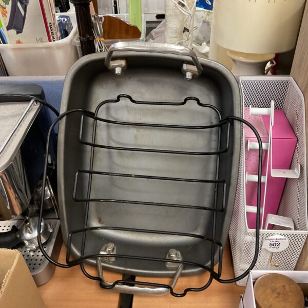 Metal turkey roasting tin with raised rails for cooking.