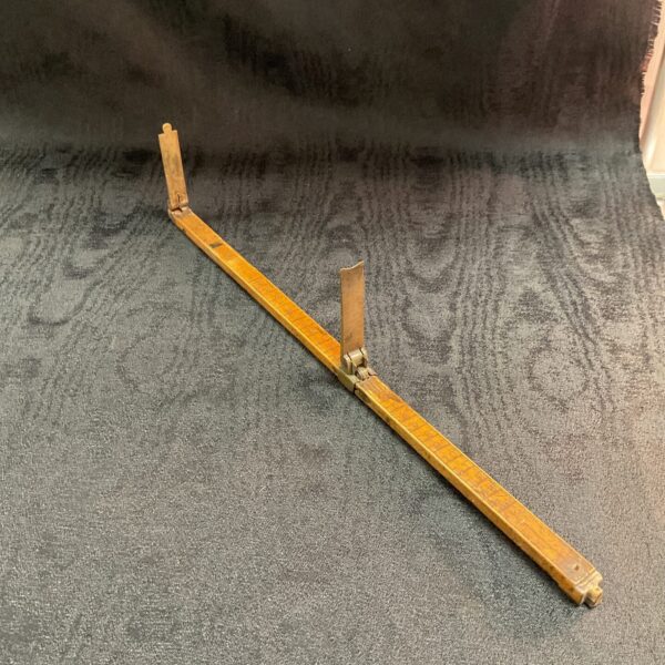 Antique Victorian foot measure open on carpet.