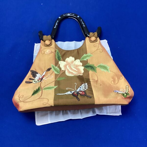 Vibrant orange Vietnamese clutch bag with floral embroidery.