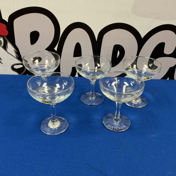Set of five vintage Babycham glasses on a patterned background.