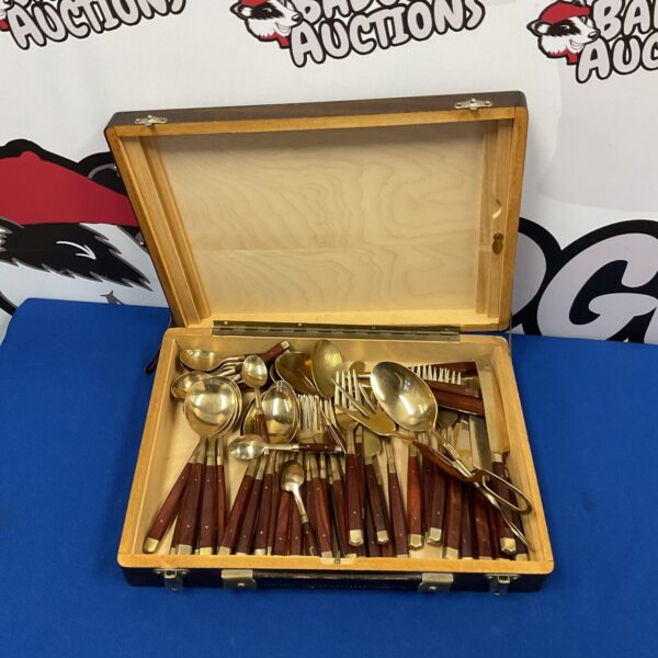 Vintage bronze cutlery set with wooden handles in a case.