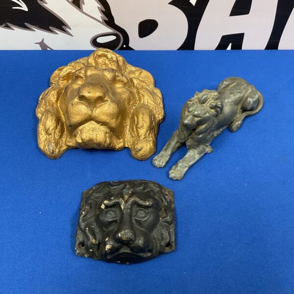 Vintage cast iron lion heads and lead lion sculpture.