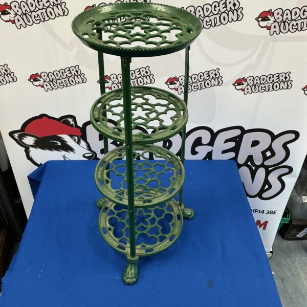 Vintage cast iron pan stand with tiered design for cookware.